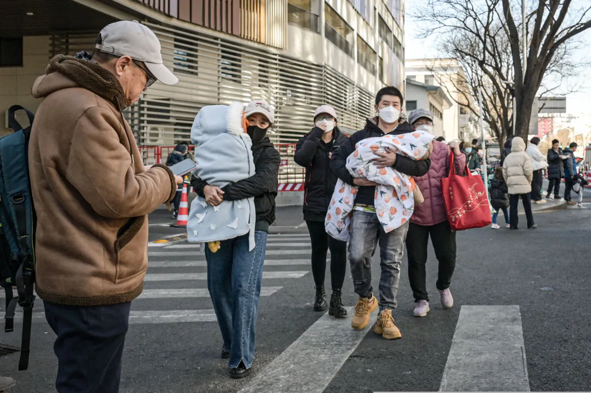 People holding their children walk out of a children's hospital in Beijing on Jan. 10, 2025. (Jade Gao/AFP via Getty Images)