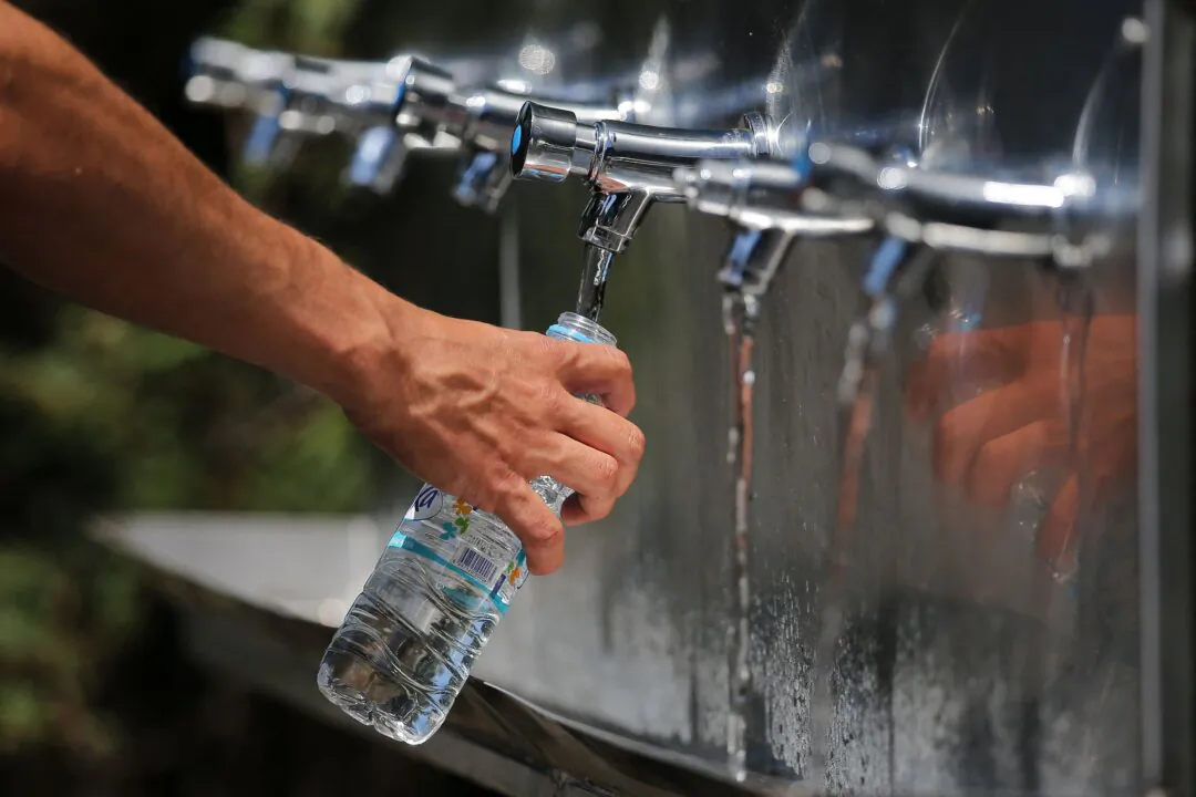 Members of the public refill bottles with water from water fountains at The All England Tennis Club in Wimbledon, southwest London, on July 2, 2018. (Daniel Leal/AFP via Getty Images)