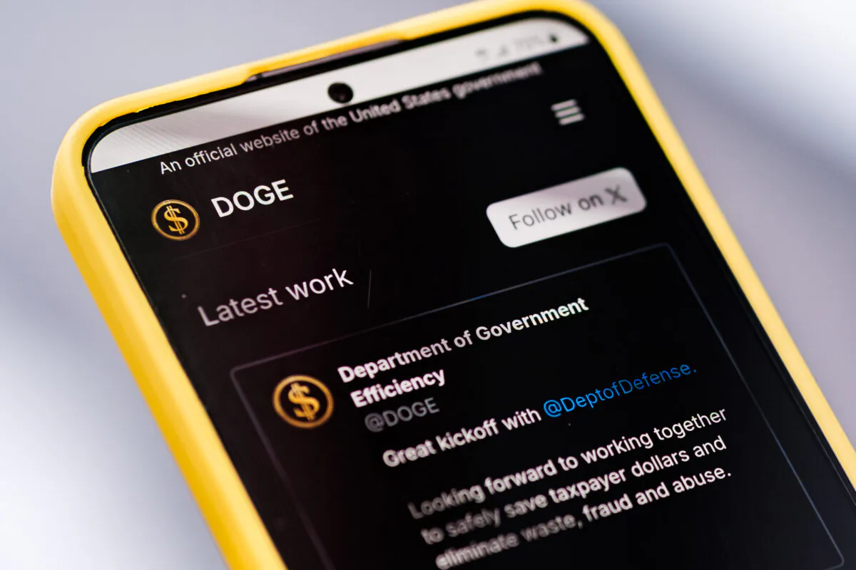 The Department of Government Efficiency (DOGE) website is displayed on a cellphone. (Oleksii Pydsosonnii/The Epoch Times)