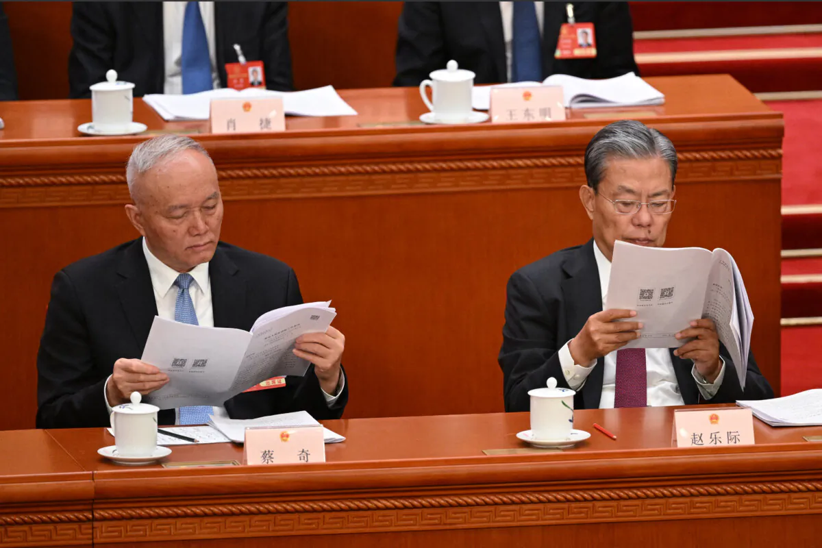 Politburo Standing Committee member Cai Qi (L) and Zhao Leji (R), chairman of the Standing Committee of China's rubber-stamp legislature, read speeches during the second plenary session of the National People's Congress at Great Hall of the People in Beijing on March 8, 2025. (Greg Baker/AFP via Getty Images)
