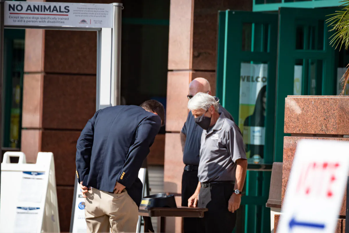 Security officials have voters go through a metal detector before entering the polling area at the Honda Center in Anaheim, Calif., on Nov. 2, 2020. (John Fredricks/The Epoch Times)