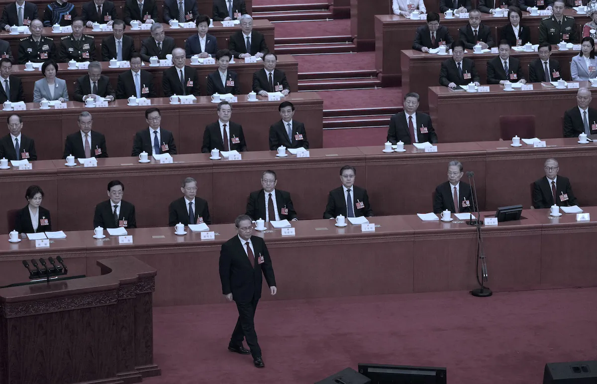 Chinese Premier Li Qiang walks to the podium as Chinese leader Xi Jinping (C) and other senior officials look on before his speech at the opening session of China's rubber-stamp legislature, the National People's Congress, at the Great Hall of the People in Beijing on March 5, 2025. (Kevin Frayer/Getty Images)