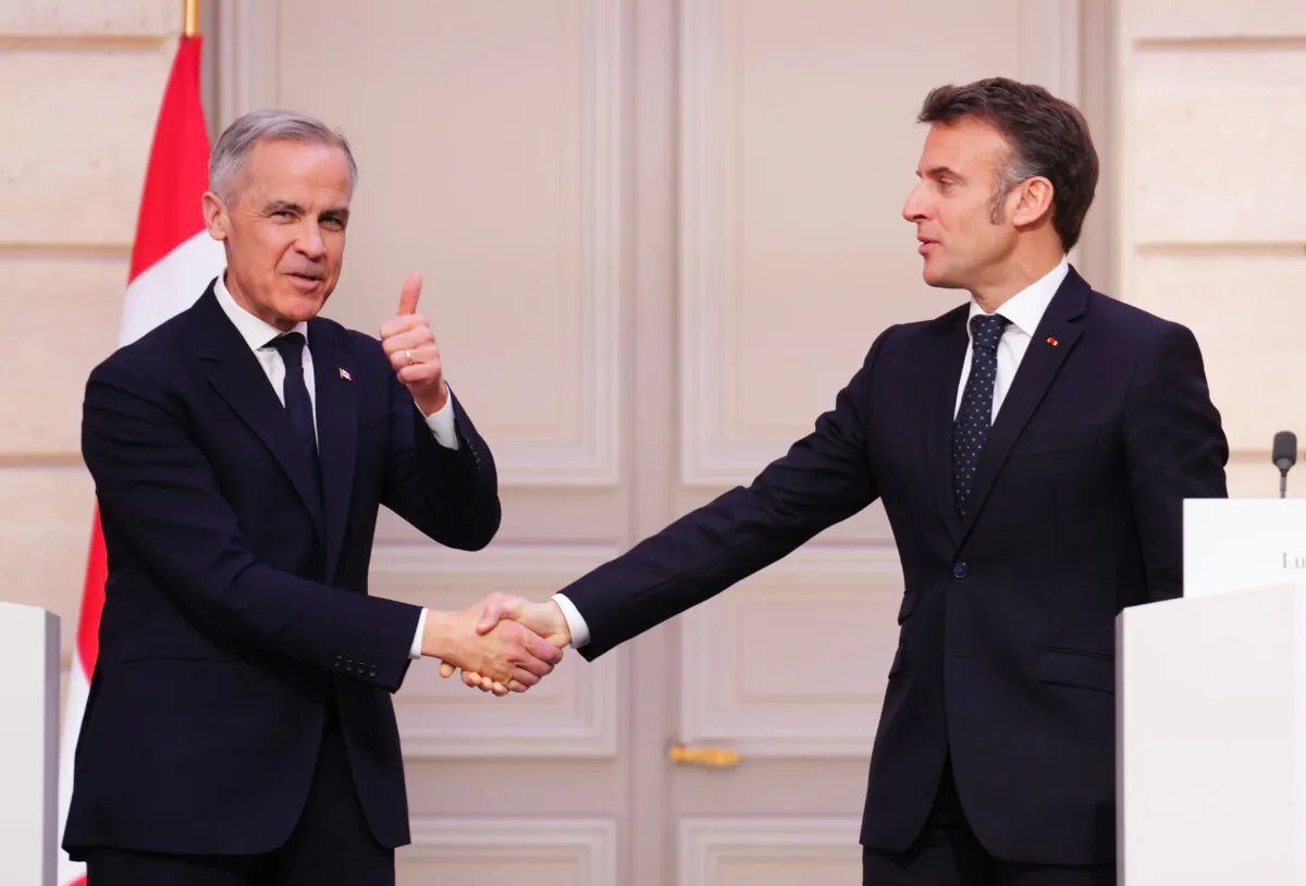Prime Minister Mark Carney (L) gives a thumbs up as he shakes hands with President of France Emmanuel Macron after delivering a joint statement at the Palais de l'Elysee in Paris, France on March 17, 2025. (The Canadian Press/Sean Kilpatrick)