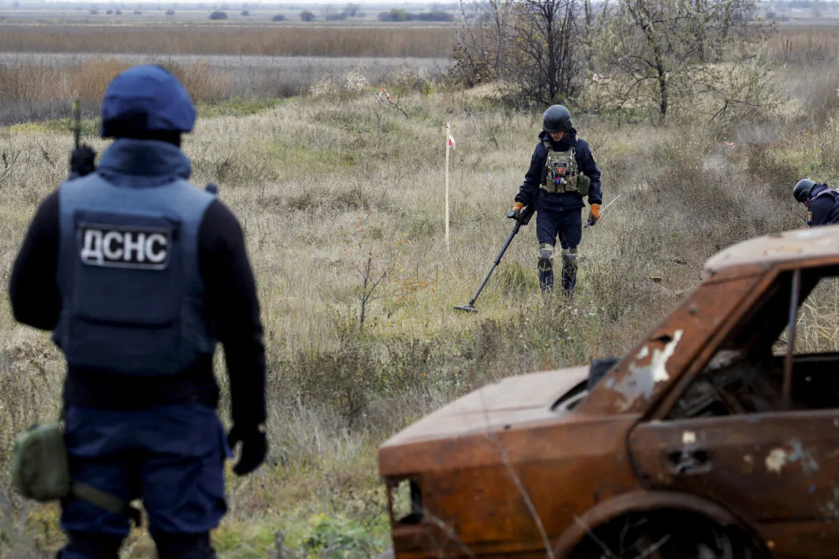 Ukrainian mine experts scan for unexploded ordnance and landmines by the main road to Kherson, Ukraine, on Nov. 16, 2022. (Murad Sezer/Reuters)