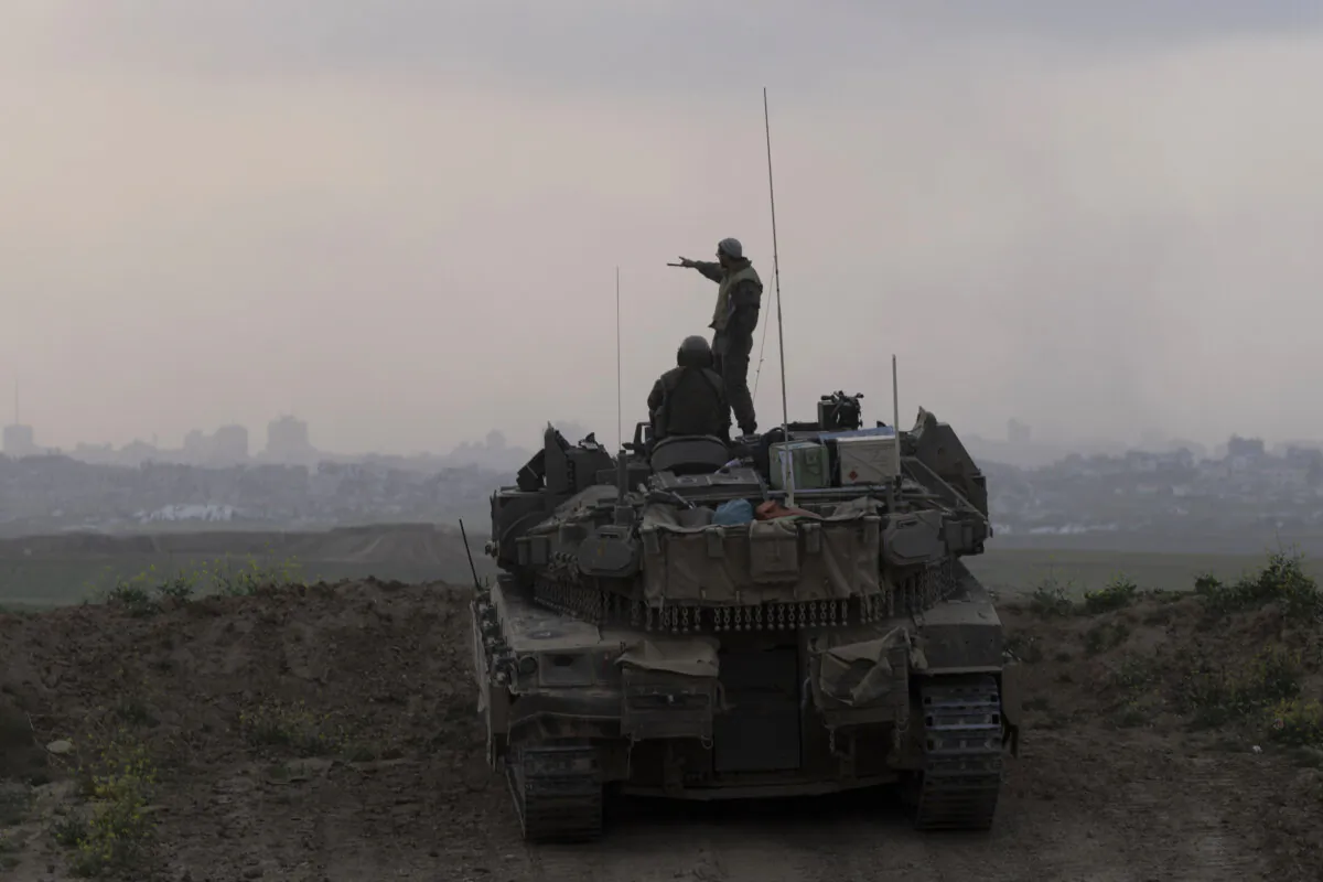 Israeli soldiers stand on a tank as it is taking position in front of the northern Gaza Strip as seen from a position on the Israeli side of the border in Southern Israel, Israel, on March 18, 2025. (Amir Levy/Getty Images)