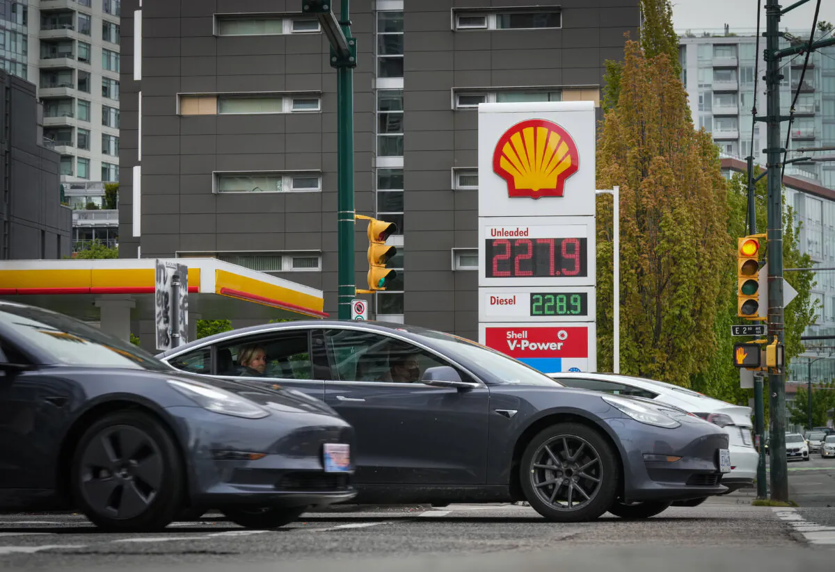 Three Tesla electric vehicles drive past a gas station in Vancouver on May 14, 2022. (The Canadian Press/Darryl Dyck)