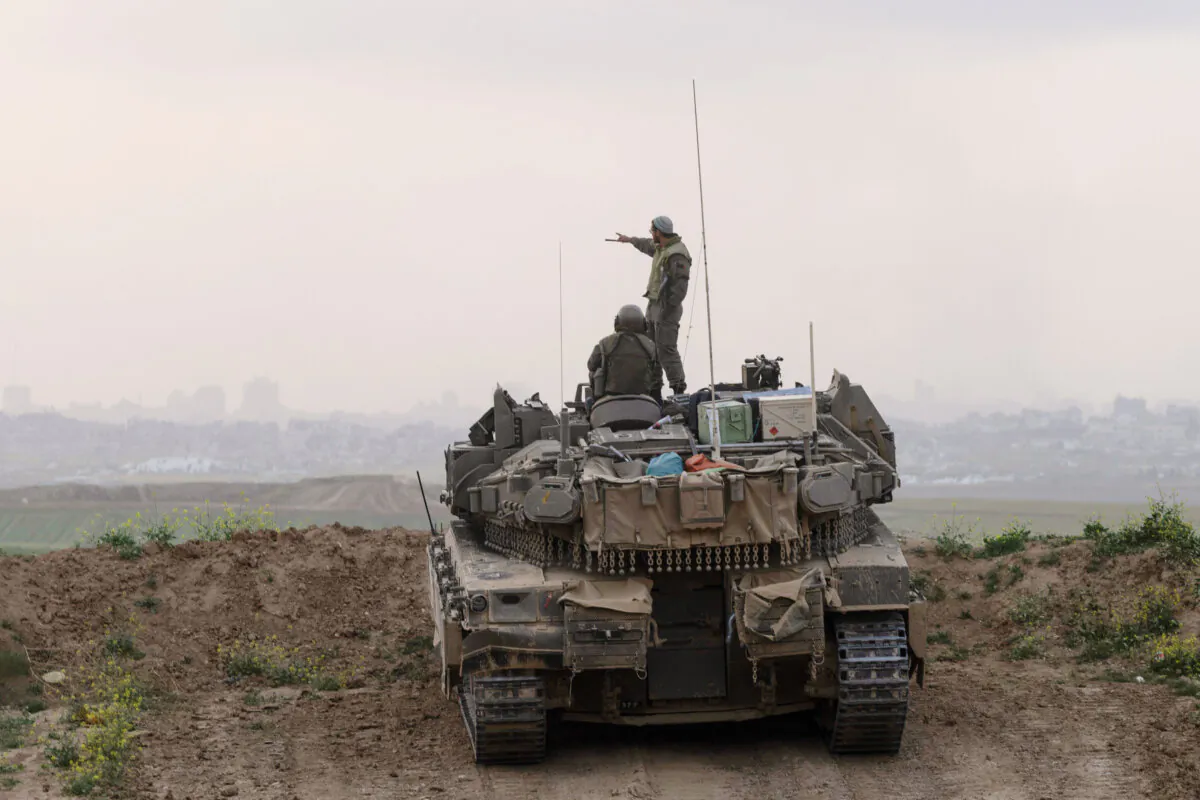 Israeli soldiers stand on a tank as it takes position in front of the northern Gaza Strip as seen from the Israeli side of the border in the Southern District of Israel, on March 18, 2025. (Amir Levy/Getty Images)