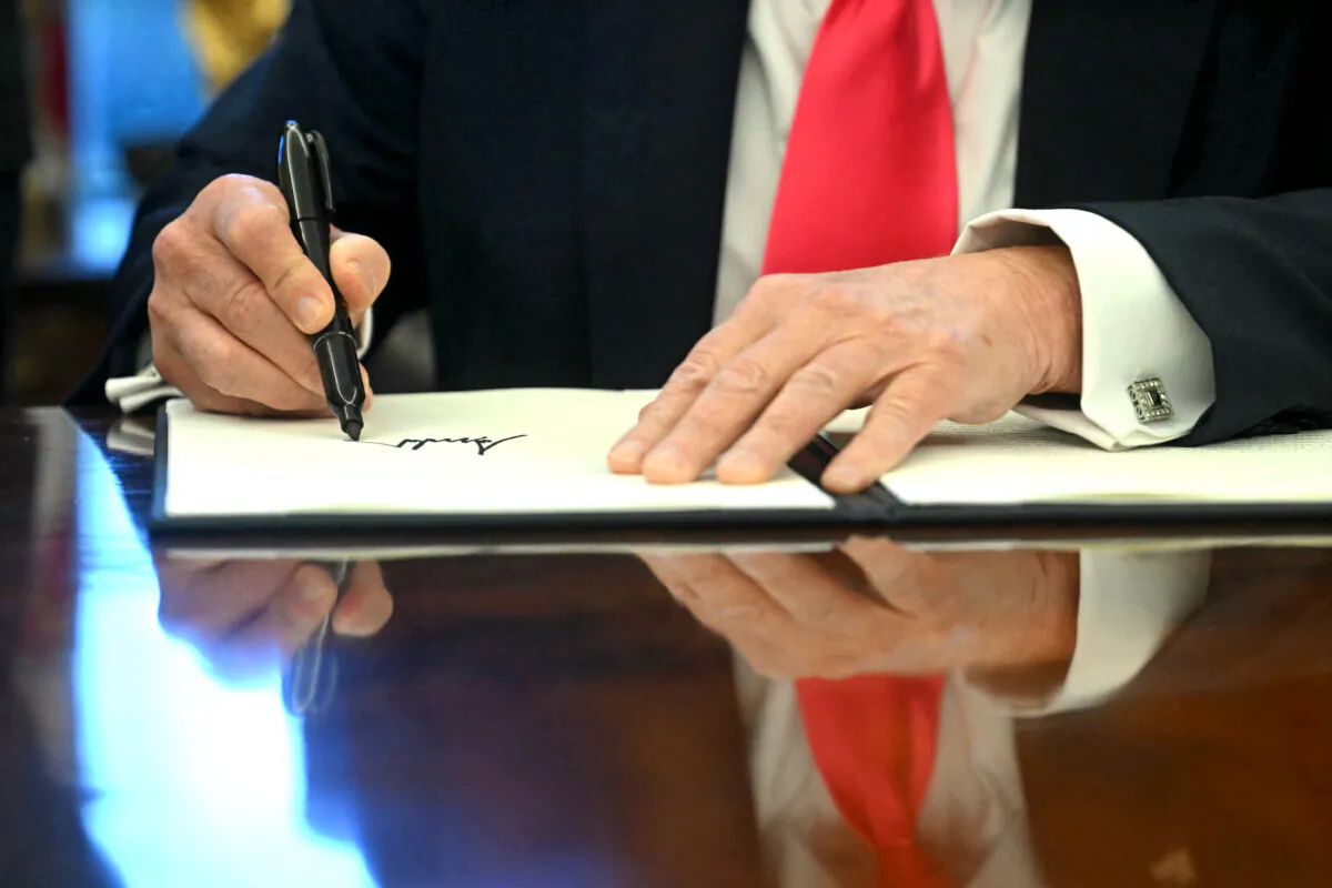 President Donald Trump signs an Executive Order at the Oval Office of the White House on Feb. 25, 2025. (Jim Watson/AFP via Getty Images)