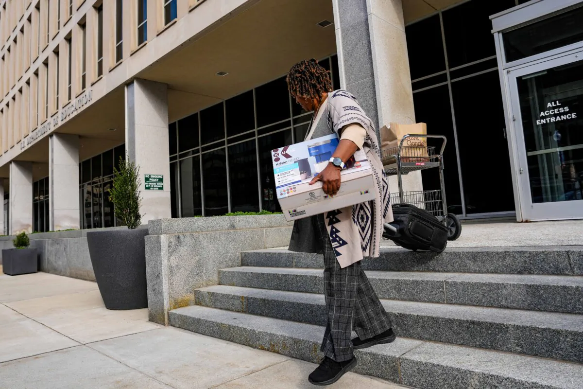A U.S. Department of Education employee leaves the building with their belonging in Washington on March 20, 2025. (Win McNamee/Getty Images)