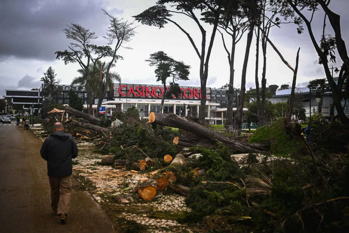 A man walks past damaged trees in front of a casino after the passage of Storm Martinho in Estoril, Portugal, on March 20, 2025. Several railway connections were disrupted in Portugal due to the storm, which is sweeping across the Iberian Peninsula and has felled numerous trees and left one person injured, according to emergency services. (Patricia De Melo Moreira/AFP via Getty Images)