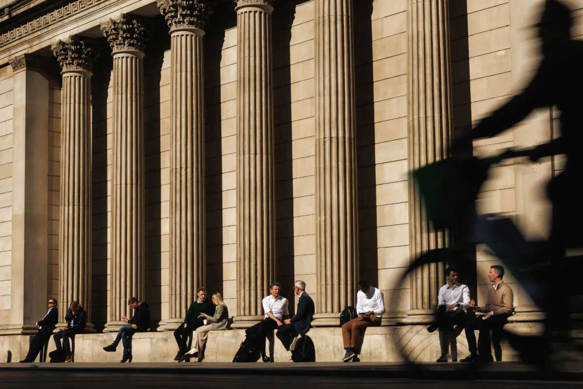 People sit on a ledge in the spring sun outside the Bank of England in London, England on March 20, 2025. (Dan Kitwood/Getty Images)