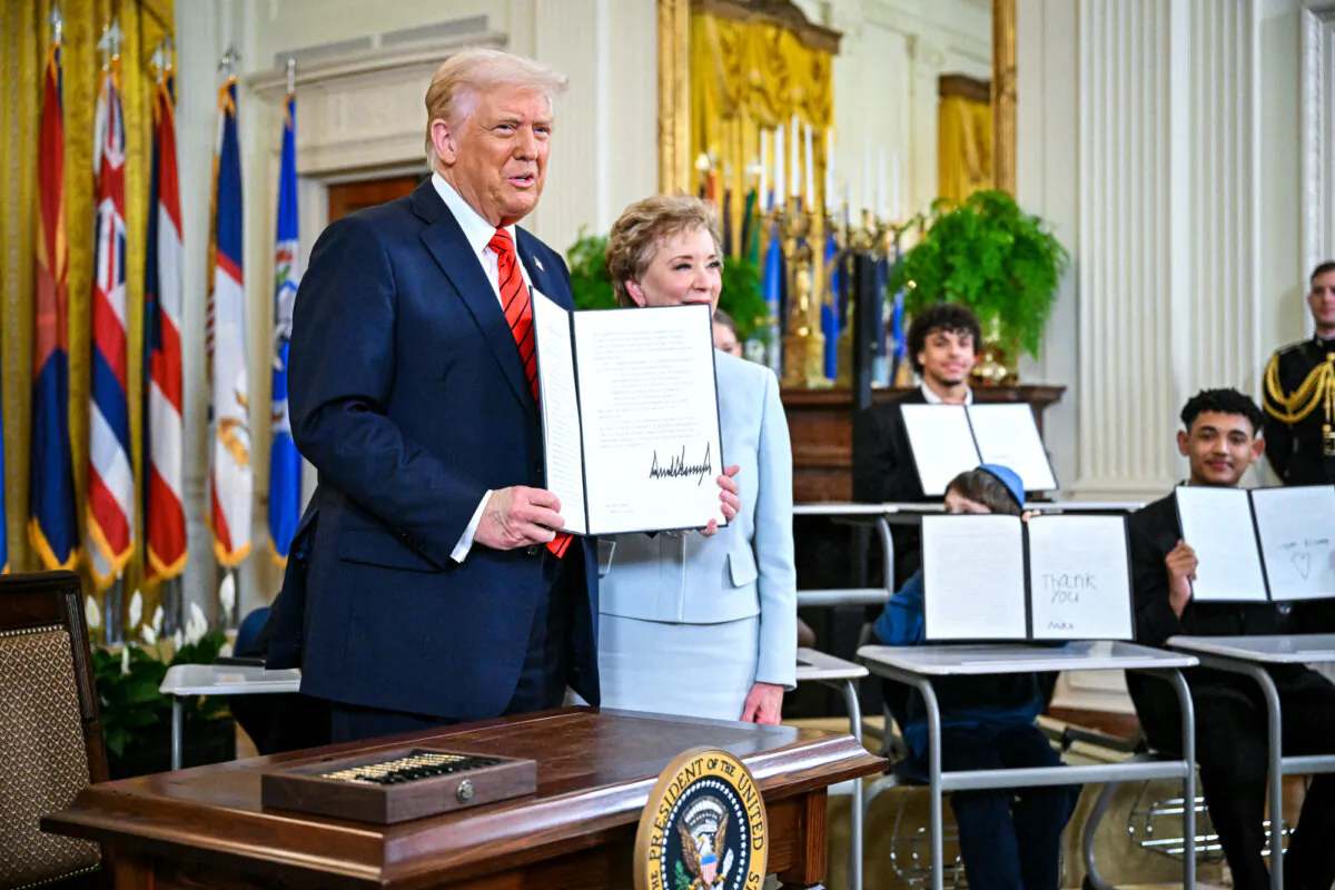 President Donald Trump holds an executive order after signing it alongside Secretary of Education Linda McMahon (R) in the East Room of the White House on March 20, 2025. (Mandel Ngan/AFP via Getty Images)
