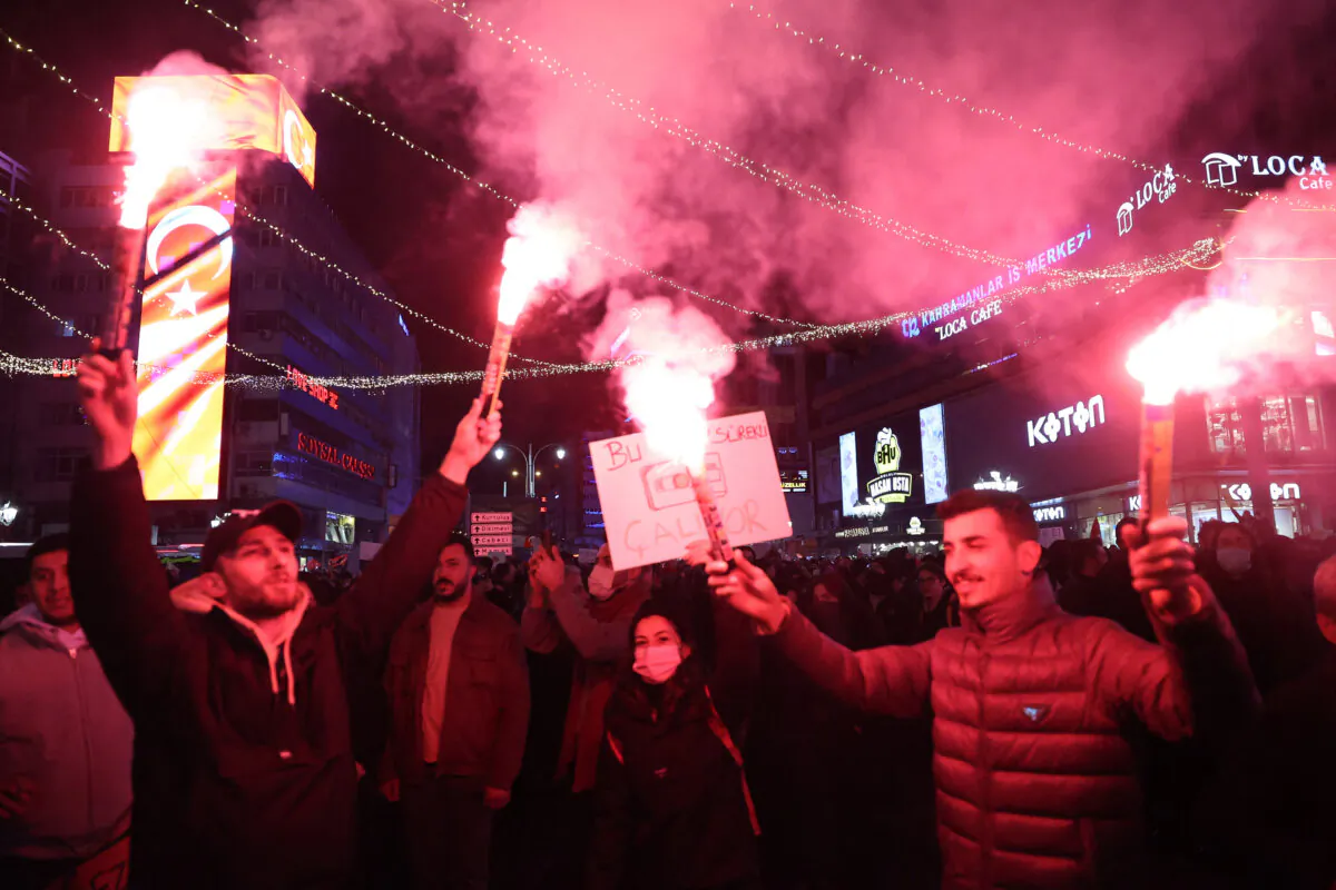 Demonstrators light flares during a clash with Turkish riot police using tear gas and water cannons during a demonstration in support of the arrested mayor of Istanbul, in Ankara, on March 23, 2025. (Adem Altan/AFP via Getty Images)