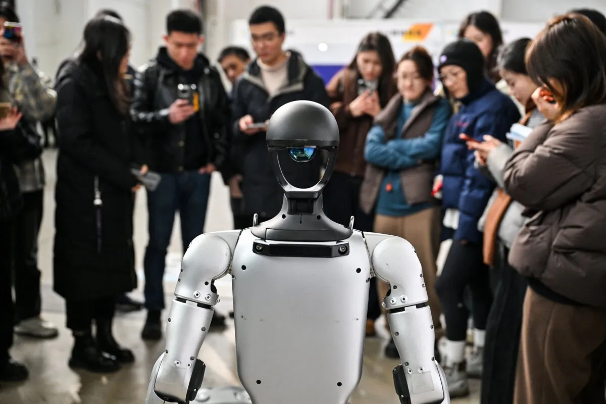 People stand next to a humanoid robot at an AI conference in Shanghai on Feb. 21, 2025. (Hector Retamal/AFP via Getty Images)