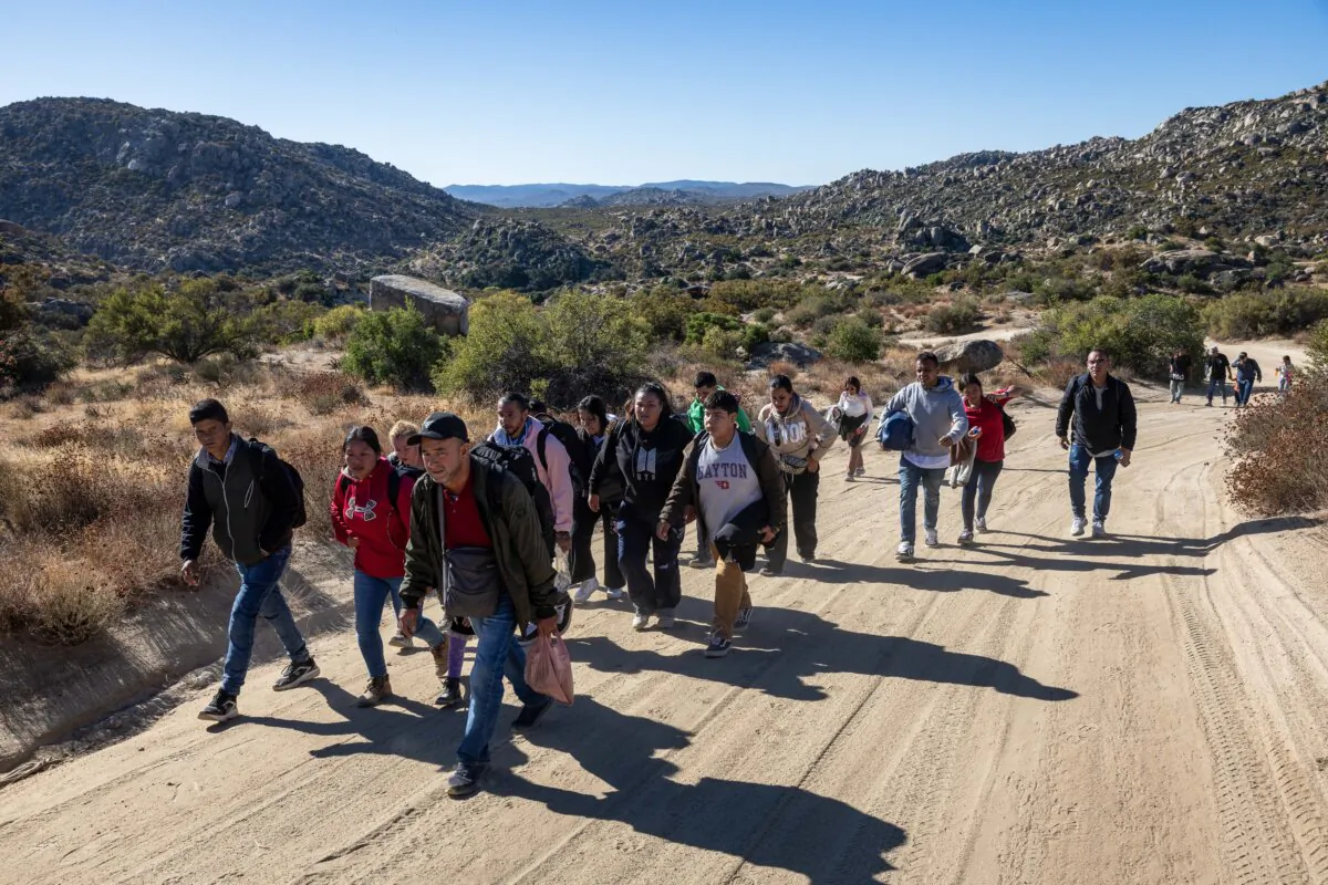 Unauthorized immigrants walk along a desert road after crossing the U.S.–Mexico border near Jacumba Hot Springs, Calif., on Sept. 22, 2024. (John Moore/Getty Images)