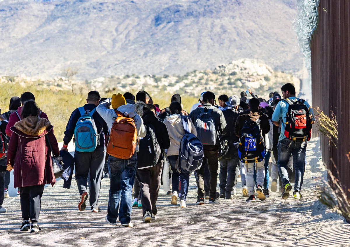 Illegal immigrants await processing by U.S. Border Patrol agents outside of San Diego, Calif., on Dec. 5, 2023. (John Fredricks/The Epoch Times)