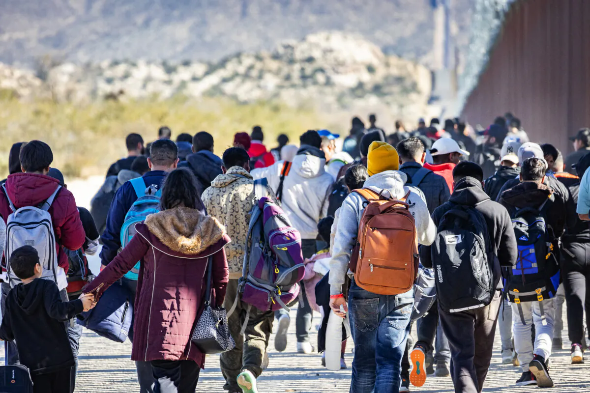Migrants who illegally crossed into the United States await processing by U.S. Border Patrol agents outside of San Diego, Calif., on Dec. 5, 2023. (John Fredricks/The Epoch Times)