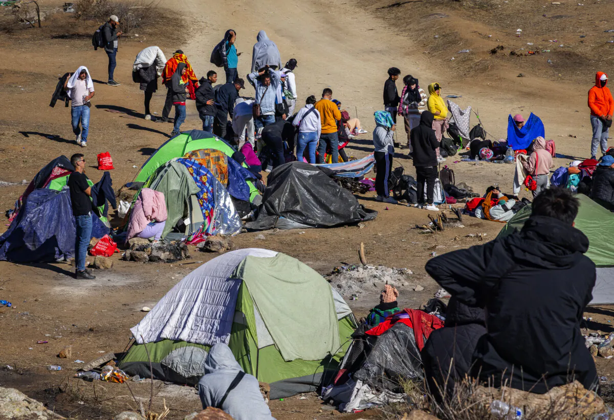 Illegal immigrants who crossed into the United States await processing by U.S. Border Patrol agents outside of San Diego on Dec. 5, 2023. (John Fredricks/The Epoch Times)