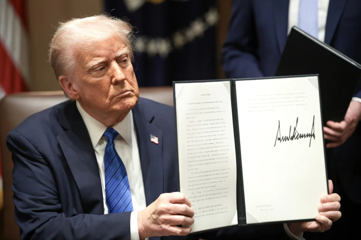President Donald Trump holds paperwork he signed, in the Cabinet Room of the White House on March 25, 2025. (Win McNamee/Getty Images)