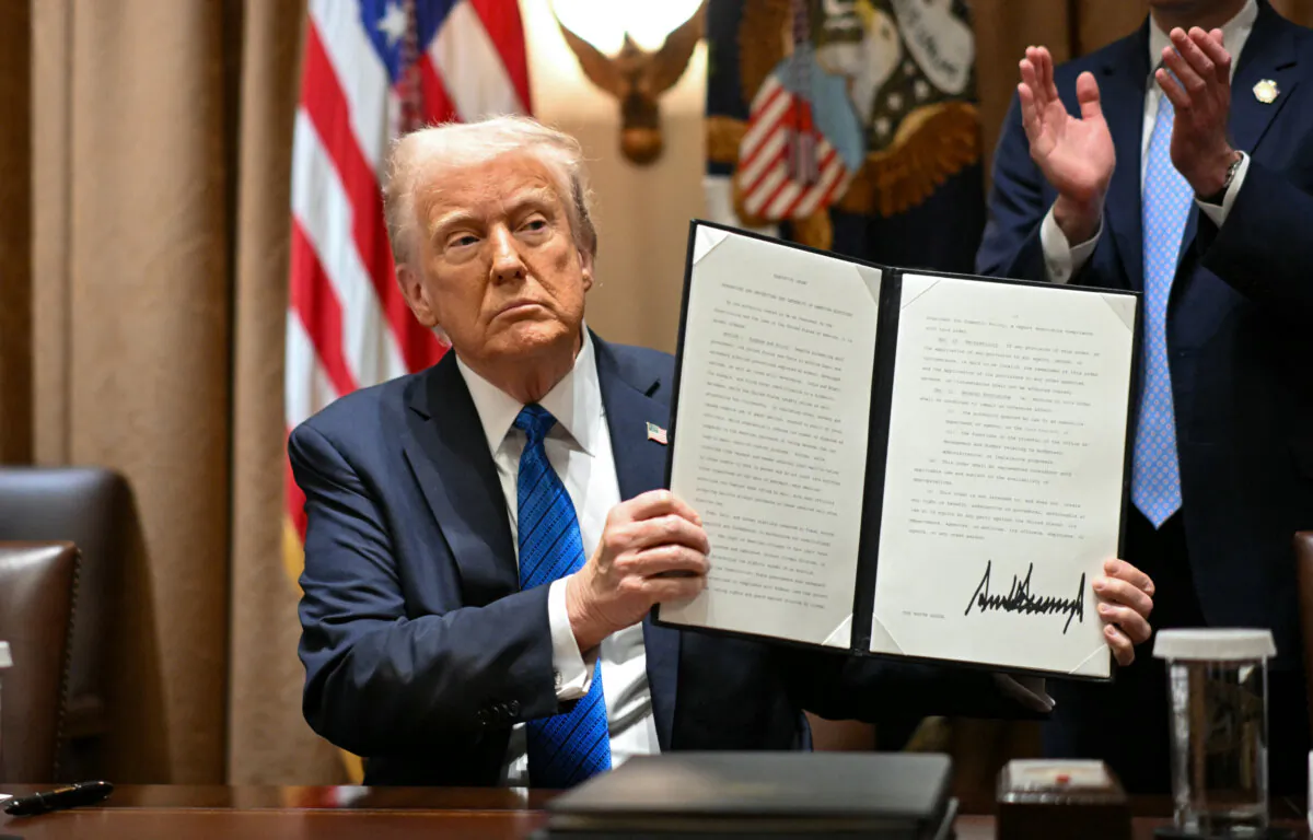 President Donald Trump displays an executive order after signing it during a meeting with U.S. ambassadors in the Cabinet Room of the White House on March 25, 2025. (Mandel Ngan/AFP via Getty Images)