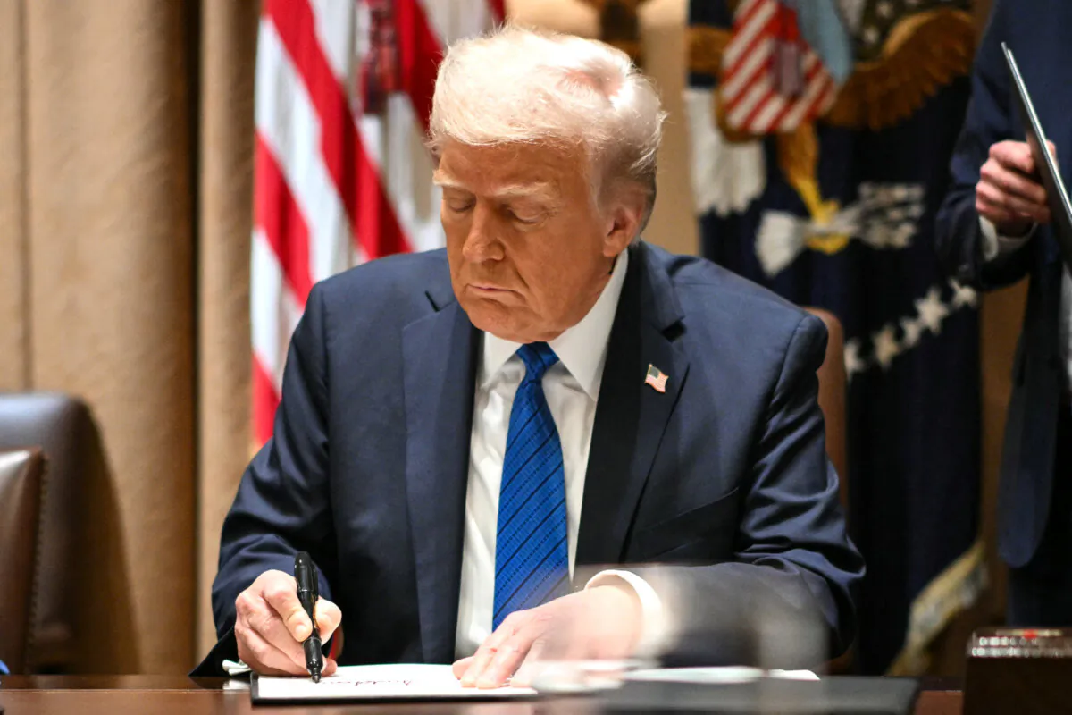 President Donald Trump signs executive orders during a meeting with U.S. ambassadors in the Cabinet Room of the White House in Washington on March 25, 2025. (Mandel Ngan/AFP via Getty Images)
