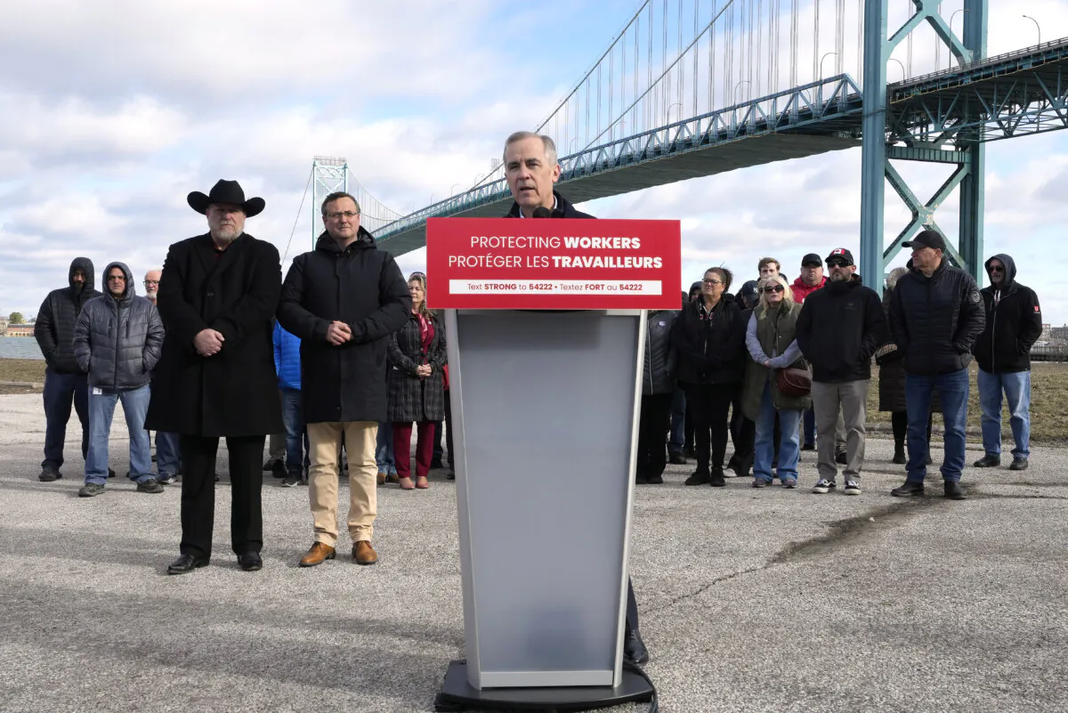 Unifor auto workers stand behind Liberal Leader Mark Carney as he speaks during a campaign stop at the Ambassador Bridge in Windsor, Ont., on March 26, 2025. (Frank Gunn/The Canadian Press)