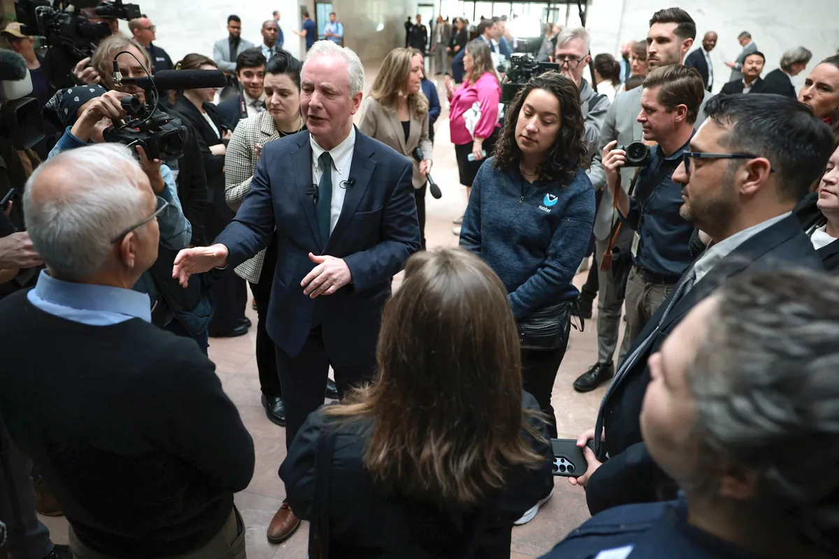 Sen. Chris Van Hollen (D-Md.) with fired government workers in Washington on March 11, 2025. (Alex Wong/Getty Images)