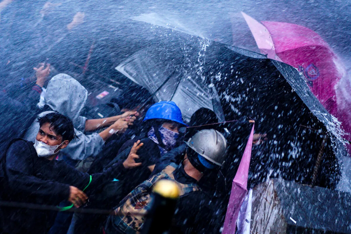 Protesters are sprayed with water cannons by police during a demonstration against a revision to the armed forces law in front of the House of Representatives building in Jakarta, Indonesia, on March 27, 2025. The Indonesian parliament approved the amendment of the military law on March 20, despite protests that it would expand the armed forces' role in civilian affairs. (Azwar Ipank/AFP via Getty Images)