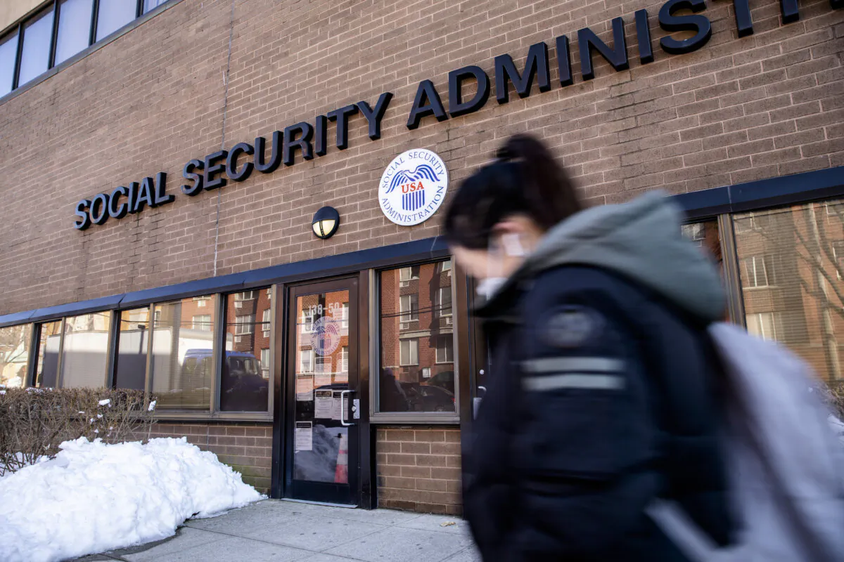A woman walks past a Social Security Administration building in Flushing neighborhood of New York City on Feb. 10, 2021. (Chung I Ho/The Epoch Times)