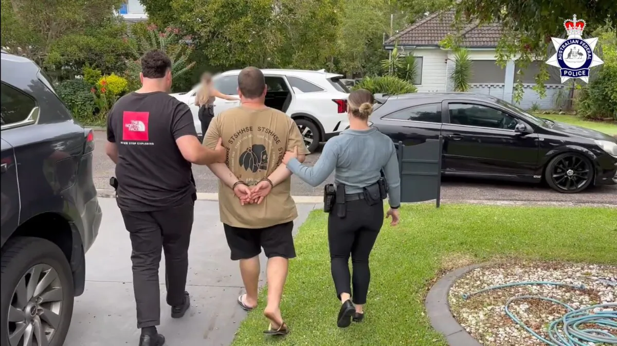The 39-year-old New South Wales man, accused of trying to import 99 kilograms of methamphetamine into Australia, is led away by detectives. (Courtesy of the Australian Federal Police)