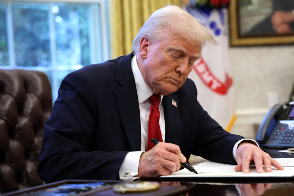 President Donald Trump signs an executive order in the Oval Office of the White House on March 26, 2025. (Win McNamee/Getty Images)