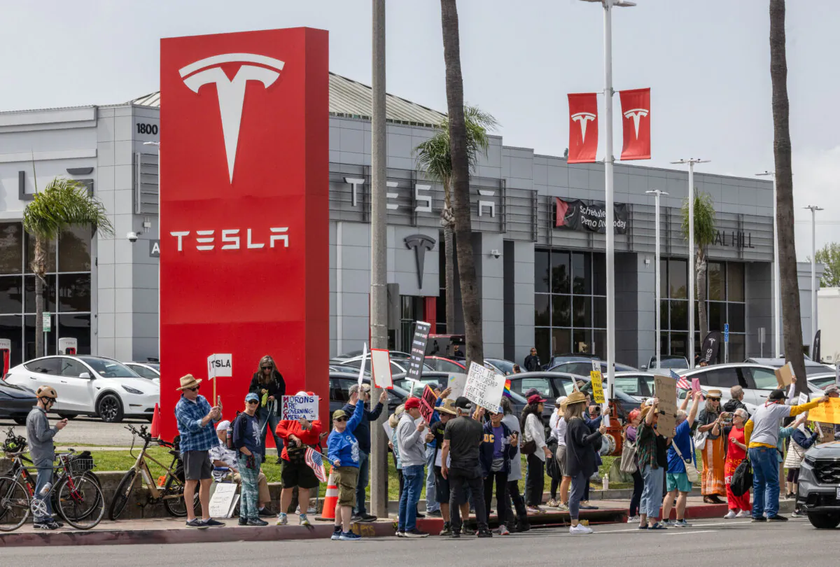 Demonstrators protest in front of a Tesla dealership in Long Beach, Calif., on March 29, 2025. (John Fredricks/The Epoch Times)