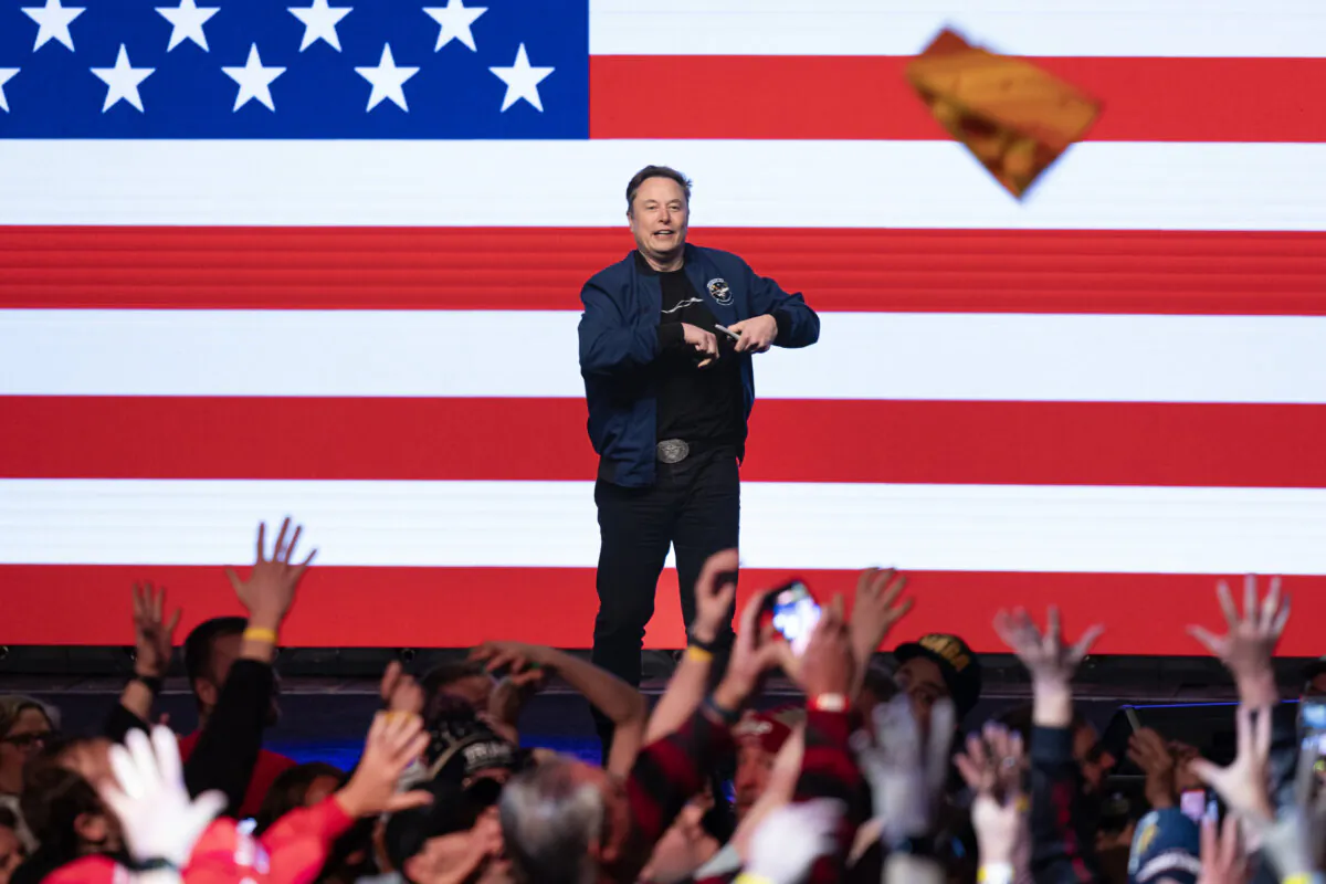 Elon Musk tosses a cheesehead hat that he arrived wearing into the crowd at a town hall meeting at the KI Convention Center in Green Bay, Wis., on March 30, 2025. (Scott Olson/Getty Images)