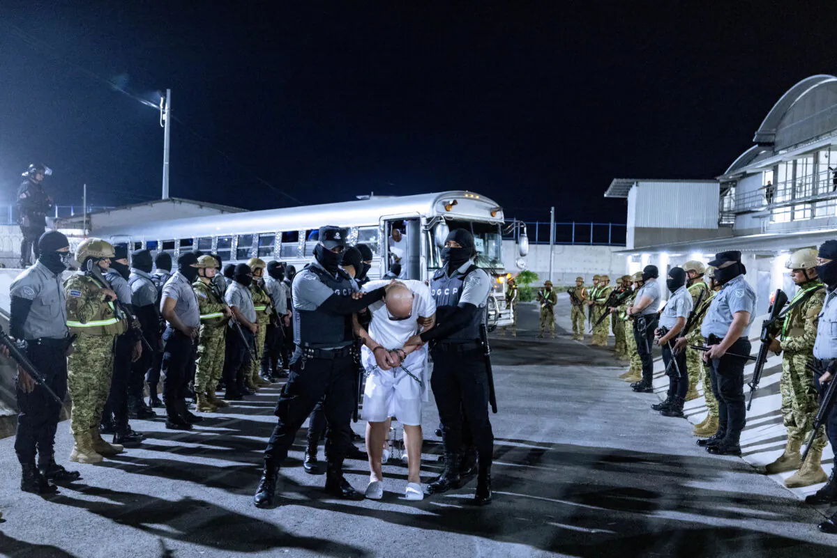 Salvadoran prison guards escort alleged members of the Venezuelan gang Tren de Aragua and the MS-13 gang recently deported by the U.S. government to be imprisoned in the Terrorism Confinement Center (CECOT) prison, as part of an agreement with the Salvadoran government, in Tecoluca, El Salvador, in this handout image obtained March 31, 2025. (Secretaria de Prensa de la Presidencia/Handout via REUTERS)