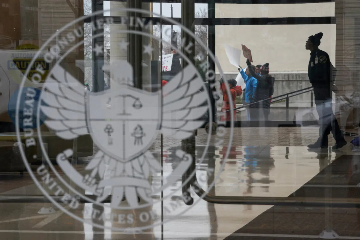 A special police member monitors a protest, while inside the Consumer Financial Protection Bureau (CFPB) building in Washington on Feb. 8, 2025. (Nathan Howard/File Photo/Reuters)