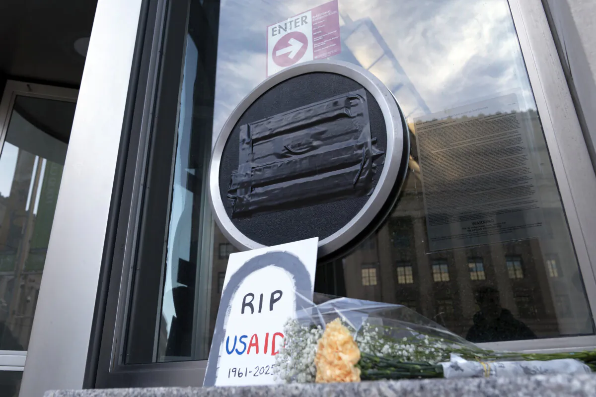 Flowers and a sign are placed outside the headquarters of the U.S. Agency for International Development, or USAID, in Washington, on Feb. 7, 2025. (Jose Luis Magana/AP Photo)
