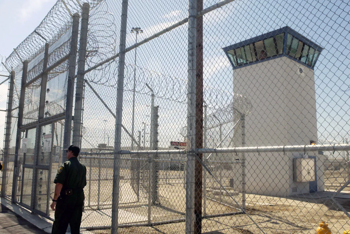A correctional officer walks near a gate, which is one of two entrances into Kern Valley State Prison in Delano, Calif., on June 14, 2005. (Ric Francis/AP Photo)