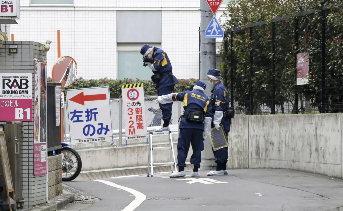Japanese police investigators work near the scene of a stabbing of a woman in the Shinjuku district of Tokyo, Tuesday, March 11, 2025. (Kyodo News via AP)