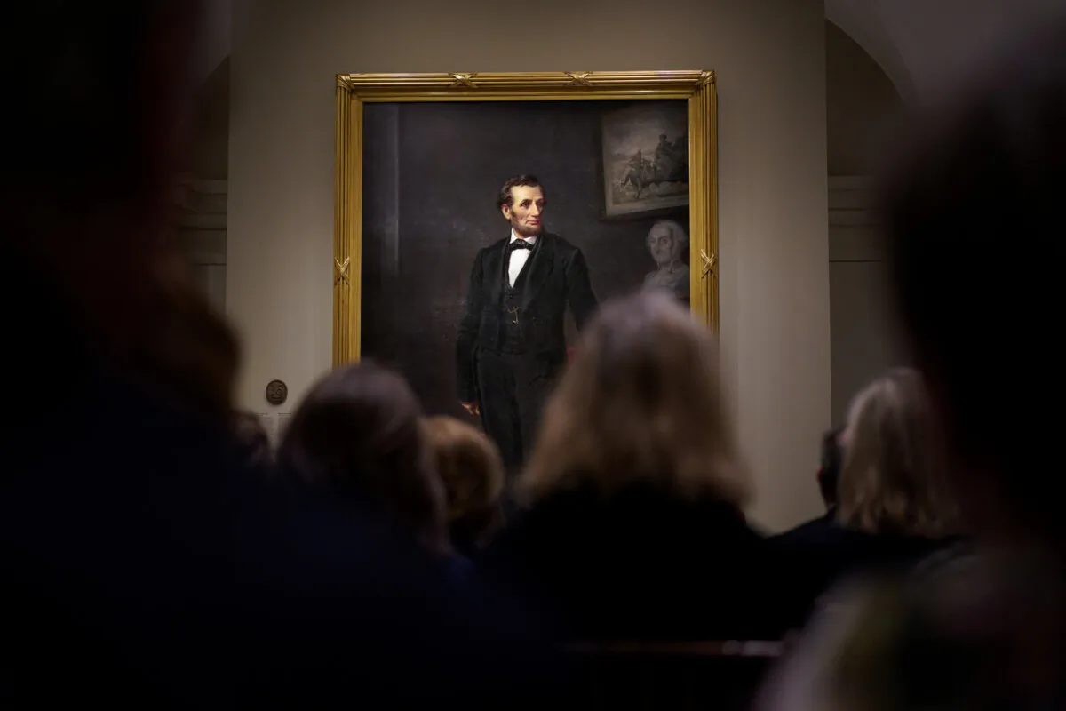 People gather for a ribbon cutting ceremony at the Smithsonian's National Portrait Gallery to announce the installation of a life-size painting of President Abraham Lincoln by artist W.F.K. Travers in Washington on Feb. 10, 2023. (Carolyn Kaster/AP Photo)
