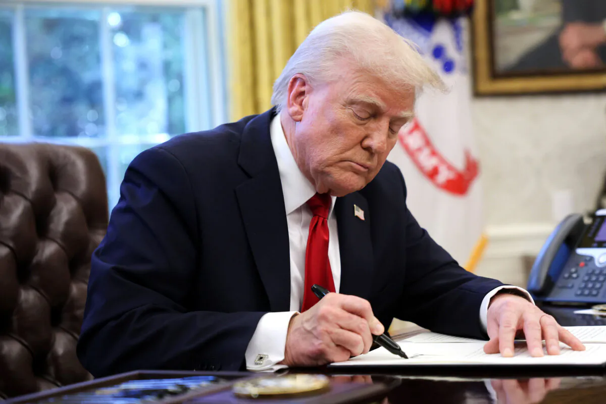 President Donald Trump signs an executive order in the Oval Office of the White House on March 26, 2025. (Win McNamee/Getty Images)