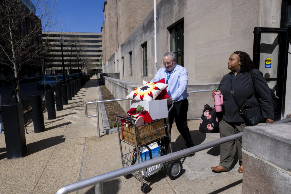 A federal worker (R), who lost her job gets help carrying some of her belongings from her office at the Mary E. Switzer Memorial Building that houses the US Department of Health and Human Services, in Washington on April 1, 2025. (Roberto Schmidt/AFP via Getty Images)