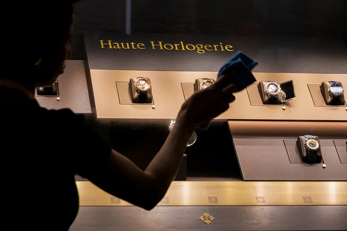 A cleaner cleans the glass of a showcase of watches at the Swiss luxury watch and clock manufacturer Patek Philipp booth during the opening day of the "Watches and Wonders Geneva" luxury watch fair, in Geneva on April 1, 2025. (Photo by FABRICE COFFRINI/AFP via Getty Images)