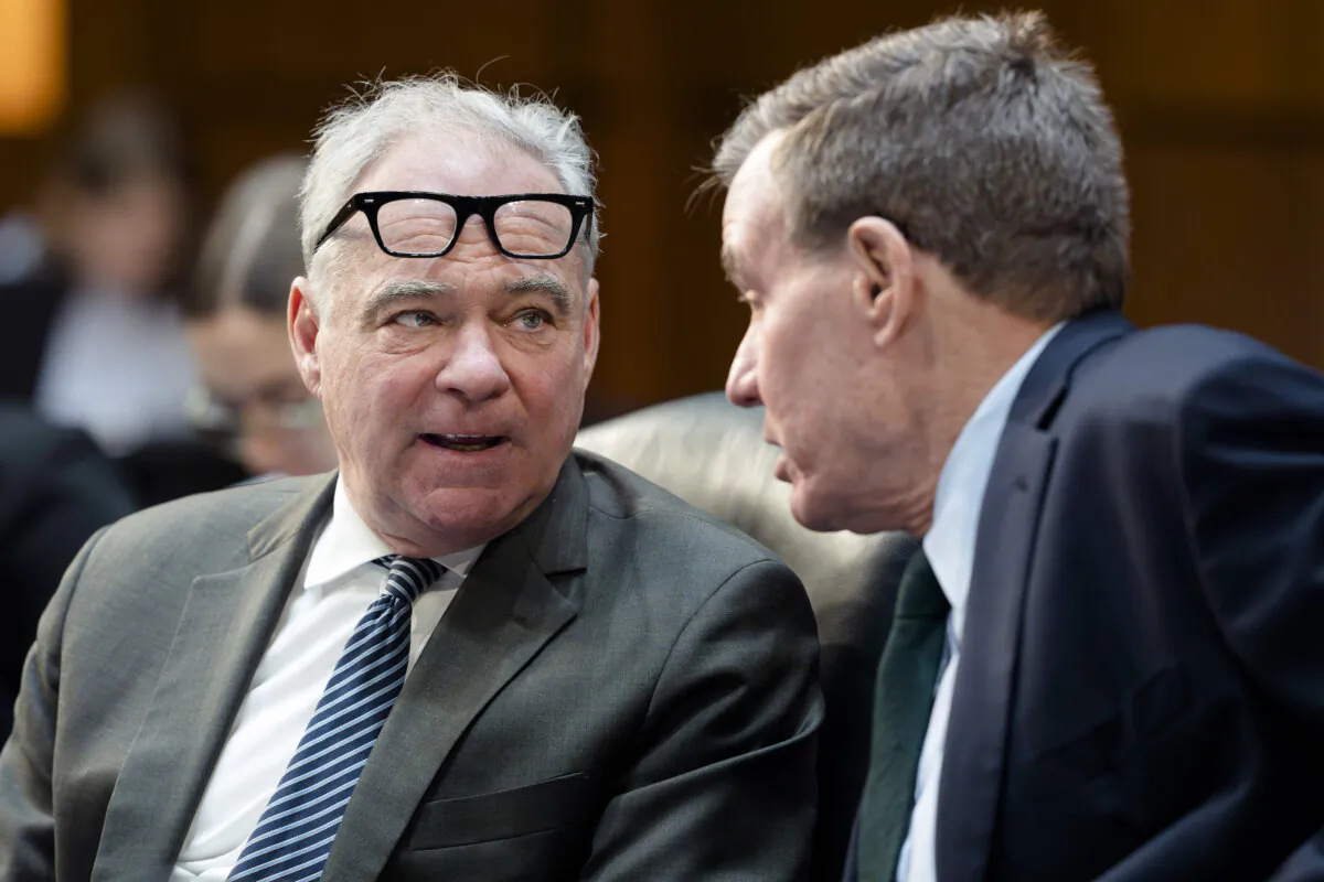 Sen. Tim Kaine, D-Va., left, and Sen. Mark R. Warner, D-Va., confer as the Senate Budget Committee works on the markup of the Fiscal Year 2025 Budget Resolution, on Capitol Hill in Washington, Wednesday, Feb. 12, 2025. Senate Republicans are vowing to move quickly on a budget plan that could pave the way for billions more in additional border security and defense spending. (AP Photo/J. Scott Applewhite)