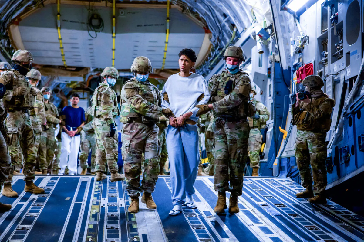 U.S. military personnel escort alleged members of the Venezuelan gang Tren de Aragua and the MS-13 gang recently deported by the U.S. government to be imprisoned in the Terrorism Confinement Center (CECOT) prison, as part of an agreement with the Salvadoran government, in San Luis Talpa, El Salvador, on March 30, 2025. (Secretaria de Prensa de la Presidencia/Handout via Reuters)