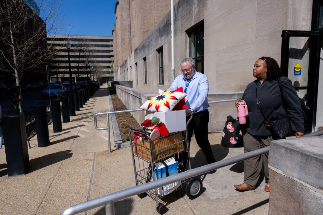 A federal worker (R), who lost her job gets help carrying some of her belongings from her office at the Mary E. Switzer Memorial Building that houses the US Department of Health and Human Services, in Washington on April 1, 2025. (Roberto Schmidt/AFP via Getty Images)