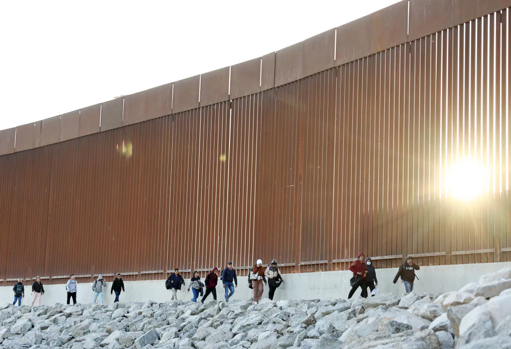 Illegal immigrants walk along the border fence on their way to being processed by U.S. Border Patrol agents after crossing into Arizona from Mexico in Yuma, Arizona, on May 11, 2023. (Mario Tama/Getty Images)