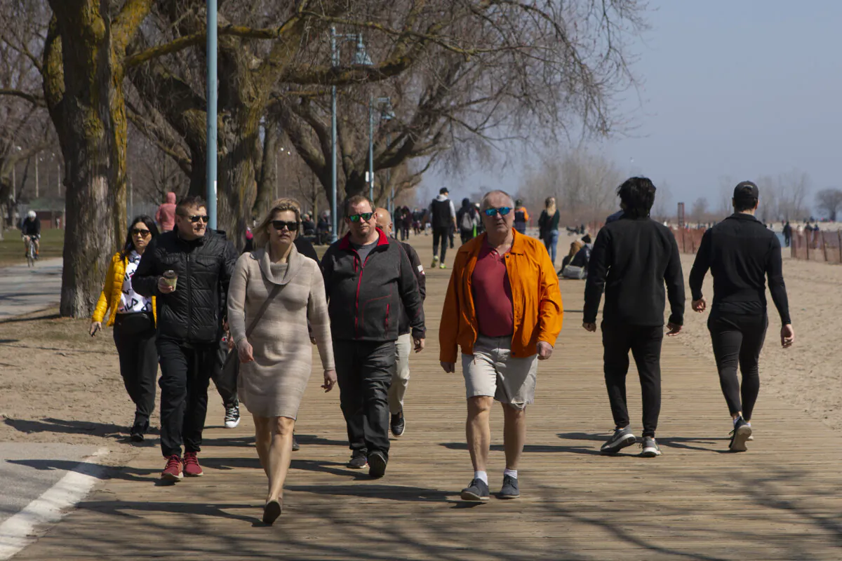 People stroll along the boardwalk in Toronto's East End on April 4, 2021. (The Canadian Press/Chris Young)