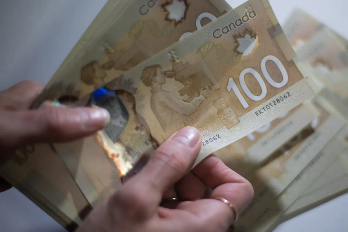 Canadian $100 bills are counted in Toronto on Feb. 2, 2016. (The Canadian Press/Graeme Roy) 