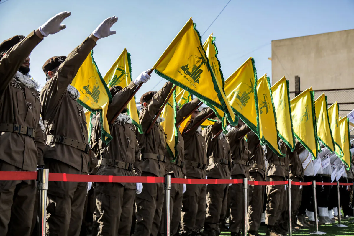 Hezbollah members salute and raise the group's flags during the funeral of their fallen comrades Ismail Baz and Mohamad Hussein Shohury, who were killed in an Israeli strike in Shehabiya, Lebanon, on April 17, 2024. (AFP via Getty Images)