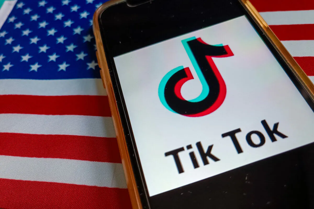 TikTok's logo is shown on a phone with the U.S. flag in a file photo. (Riccardo Milani/Hans Lucas/AFP via Getty Images)